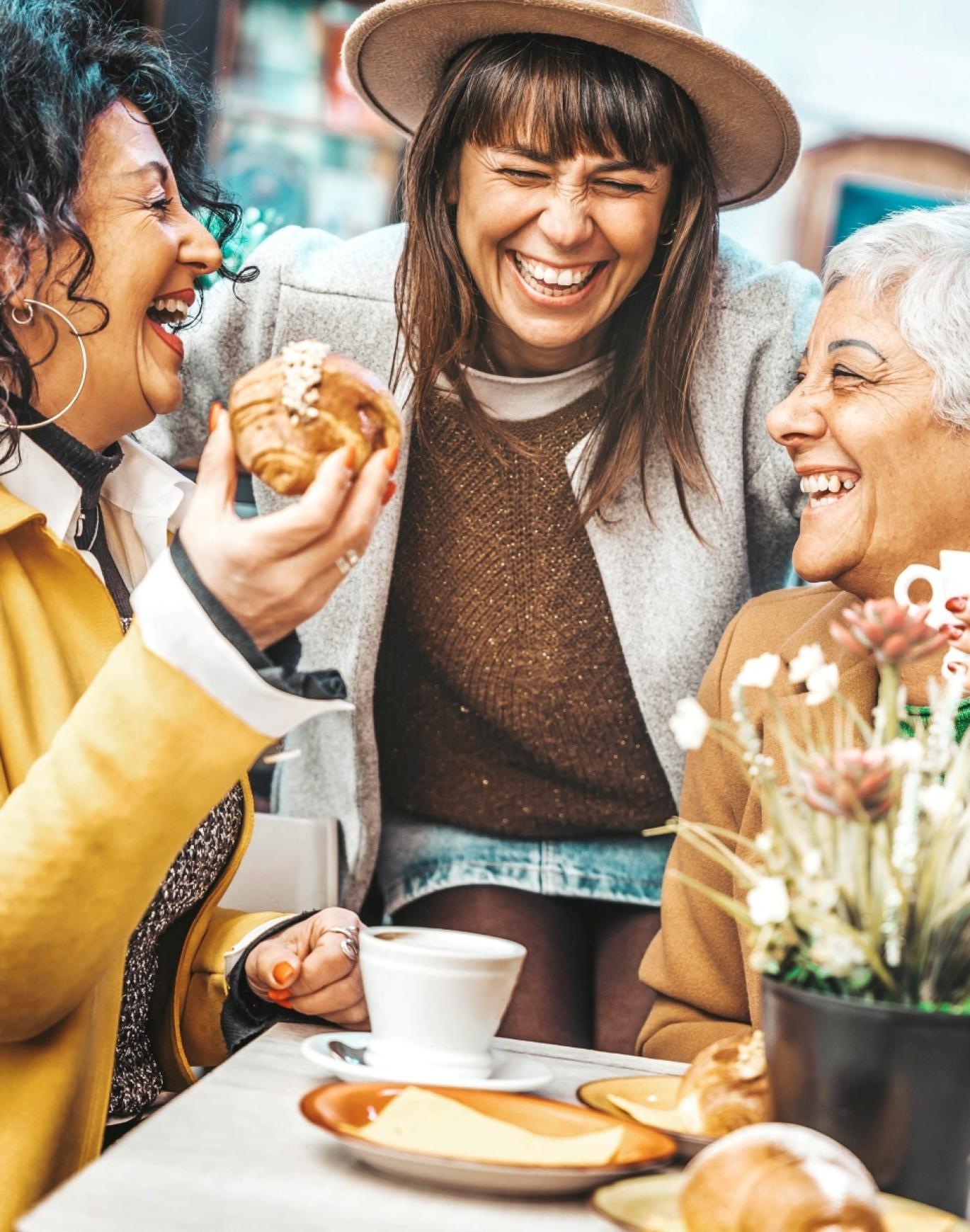 a group of women laughing and eating